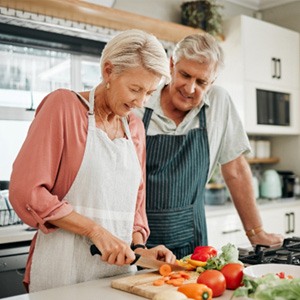 An elderly couple preparing healthy foods to eat