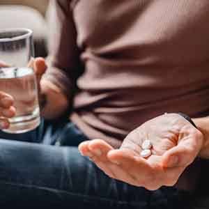 a person taking pills after oral surgery