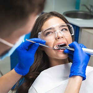 A dentist performing a root canal treatment on a woman