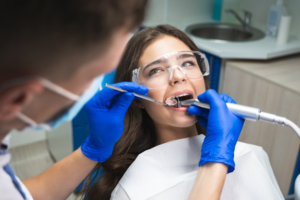 Dentist examining young woman’s mouth