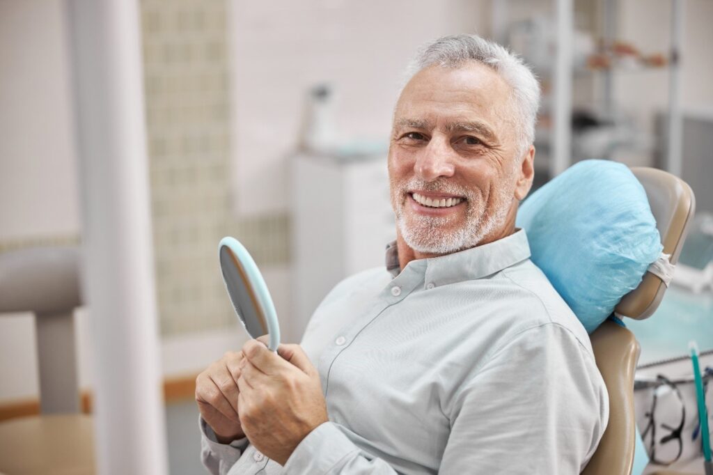 person looking at their tooth in the mirror