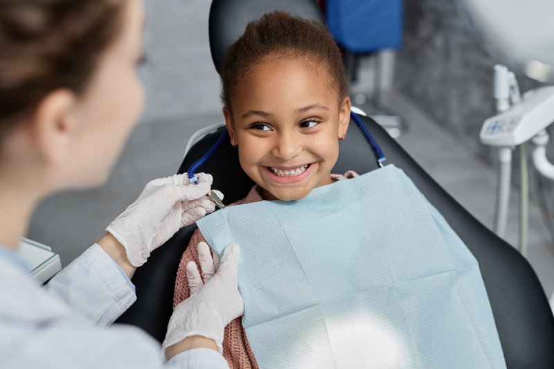 Girl smiles in dentist's chair